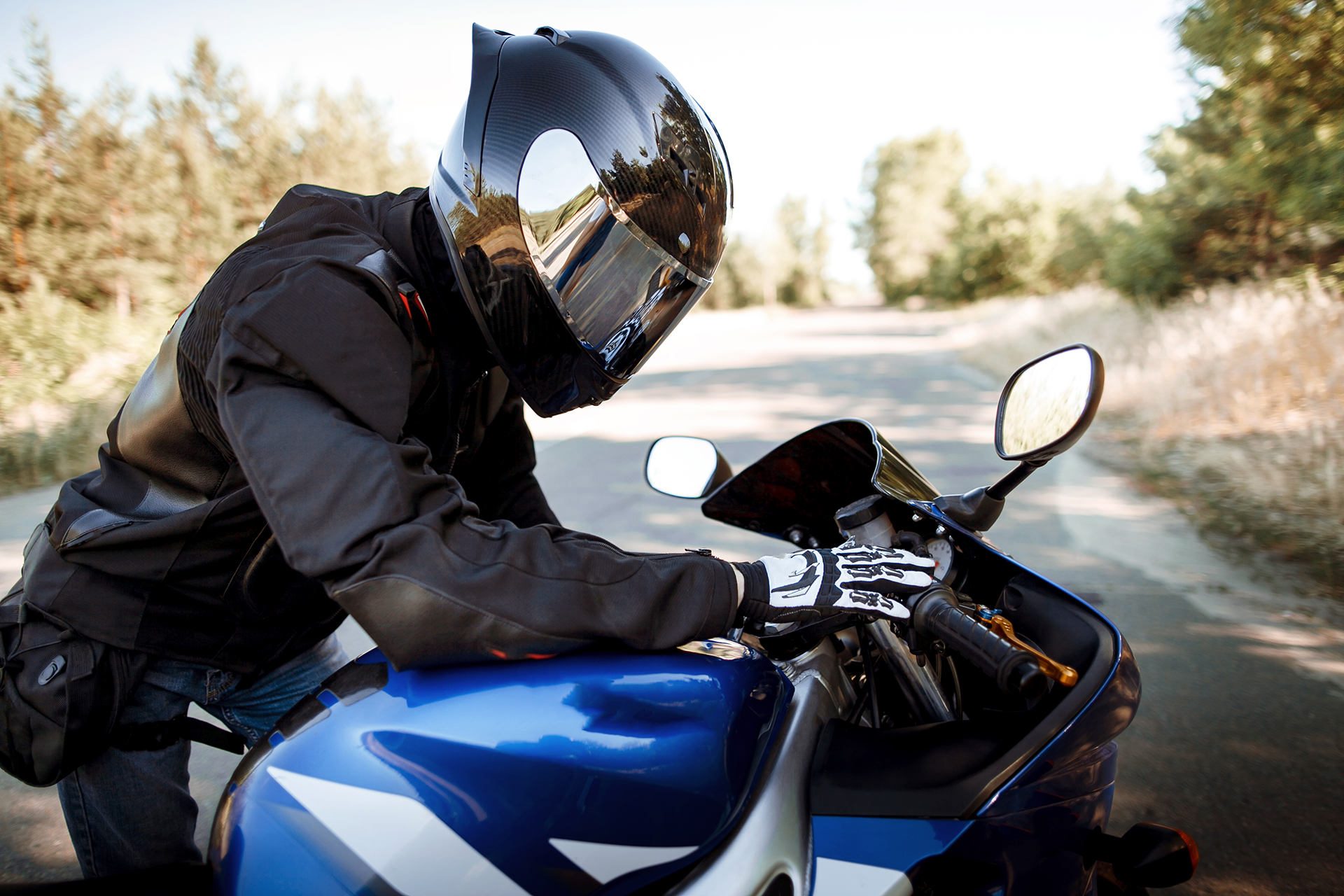 motorcycle driver helmet leather jacket sits sports motorcycle road against forest background beautiful background place copy space